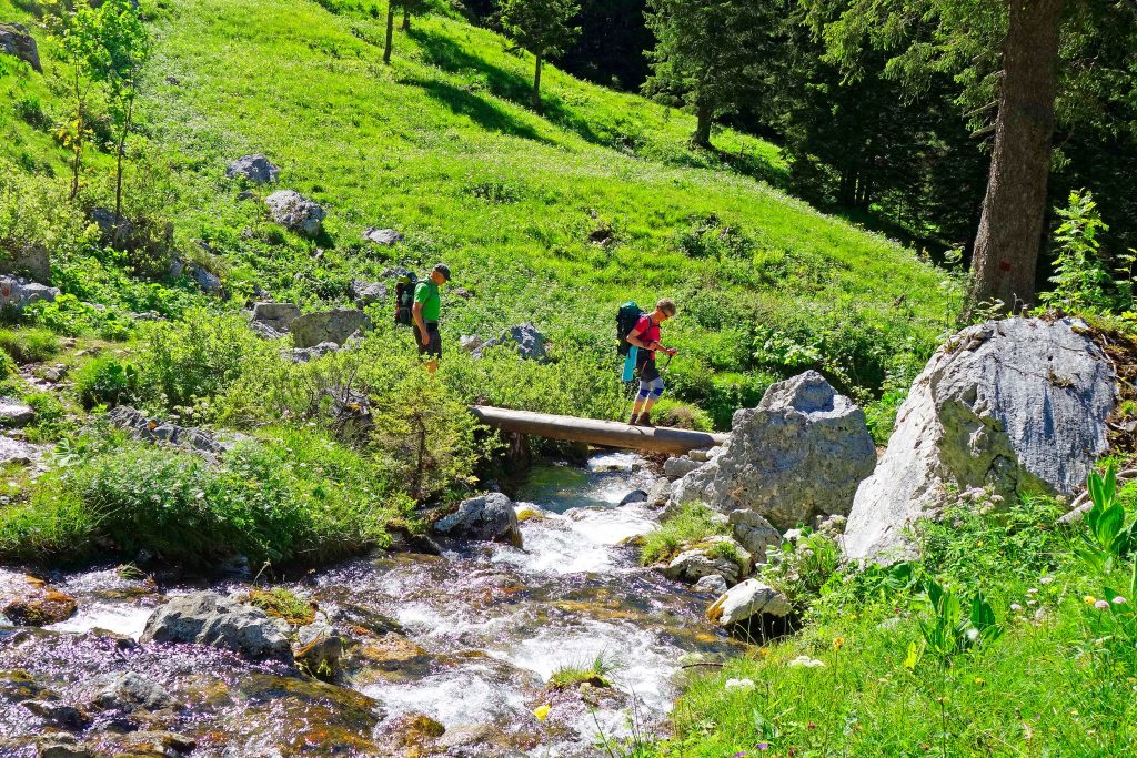 Wandern-von-Füssen-nach-Rosenheim---Wanderer-bei-Bachquerung