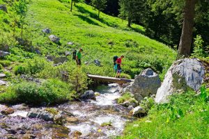 Wandern-von-Füssen-nach-Rosenheim---Wanderer-bei-Bachquerung